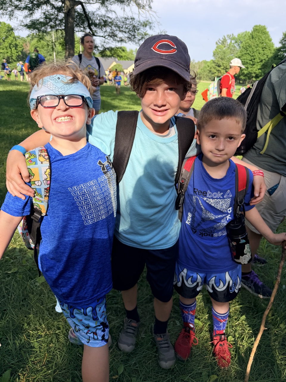 Scouts with arms around each other at an outdoor event